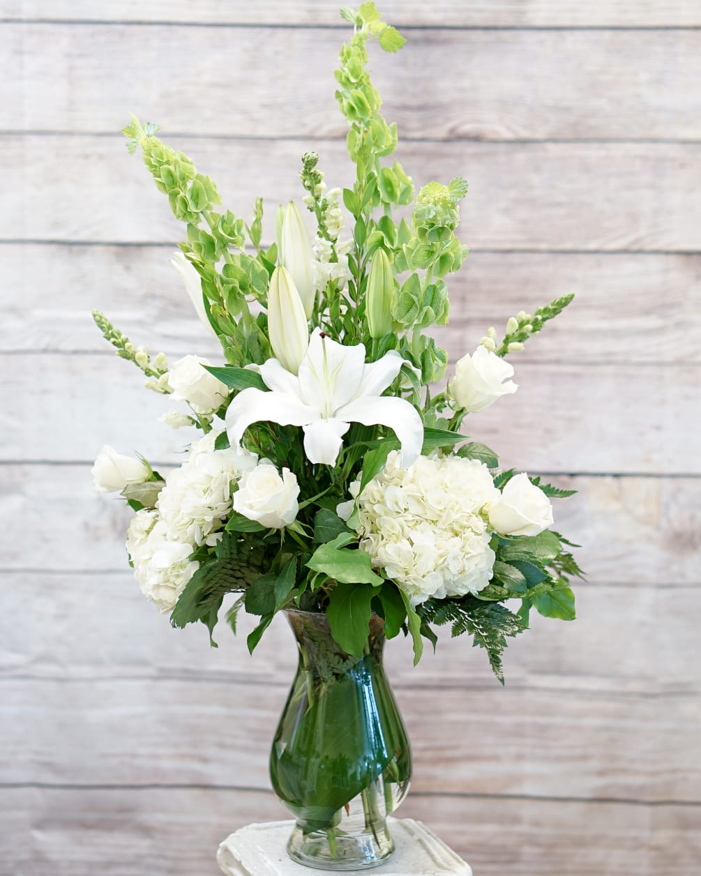 Tall and airy arrangement of white hydrangeas, oriental lilies, roses, snapdragon and
