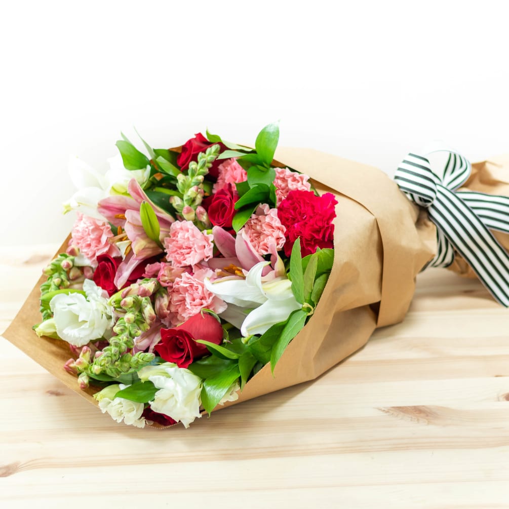 A gorgeous wrapped bouquet designed with premium red and pink blooms and