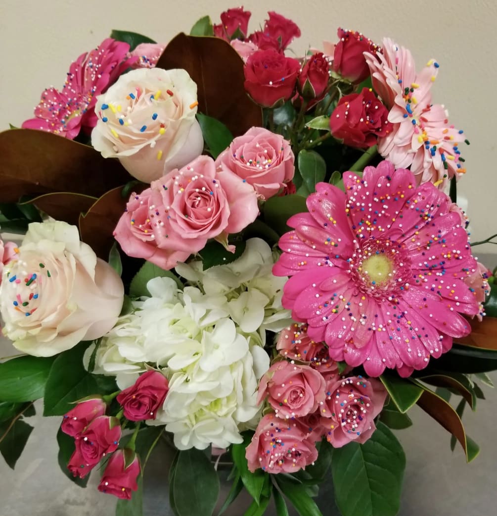 This delightful arrangement of roses, gerbera daisies, spray roses, and hydrangea are