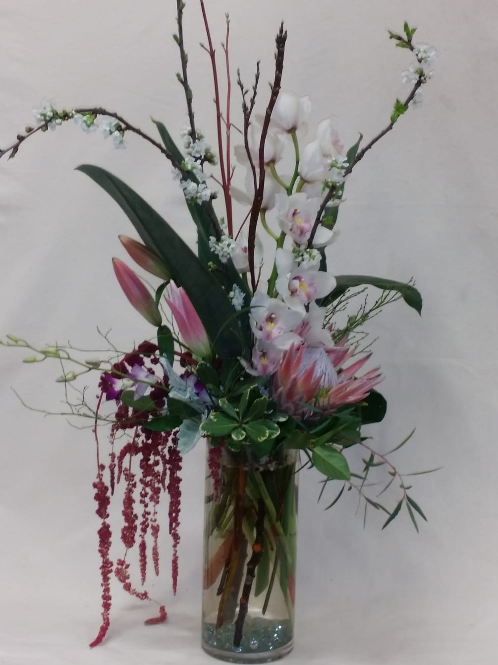 A contemporary design in a large glass cylinder. Gorgeous white cymbidium orchids