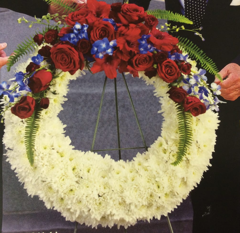 Wreath of roses, chrysanthemums, blue delphinium for a funeral service or military