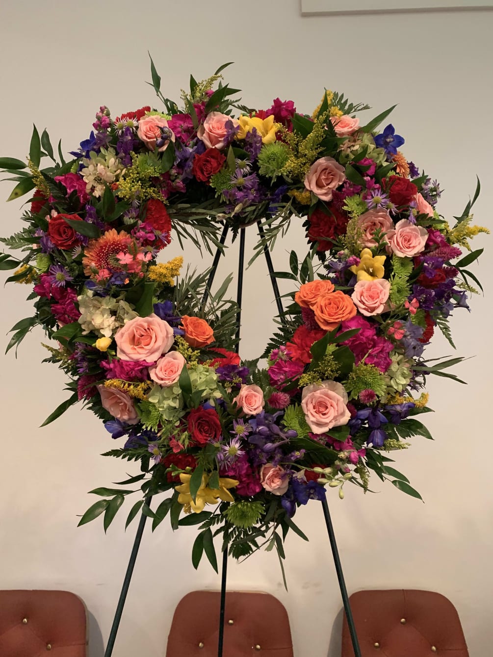 A floral heart wreath with seasonal mixed flowers 