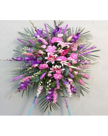 A lovely standing spray with purple and pink flowers. 

