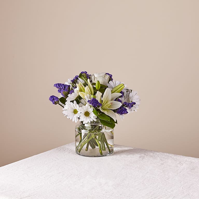 The  Touch of Blue bouquet is designed with billowing white blooms