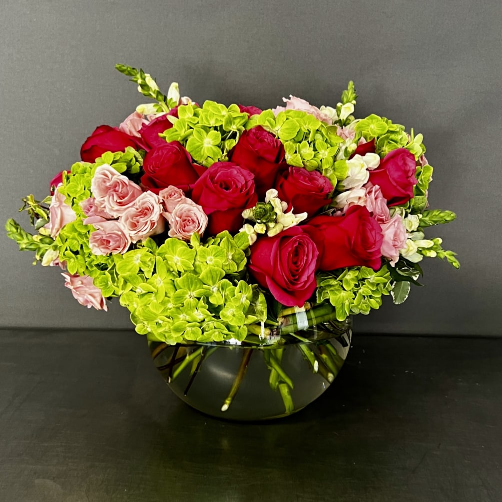 This arrangement has hydrangeas and roses and it is designed in an