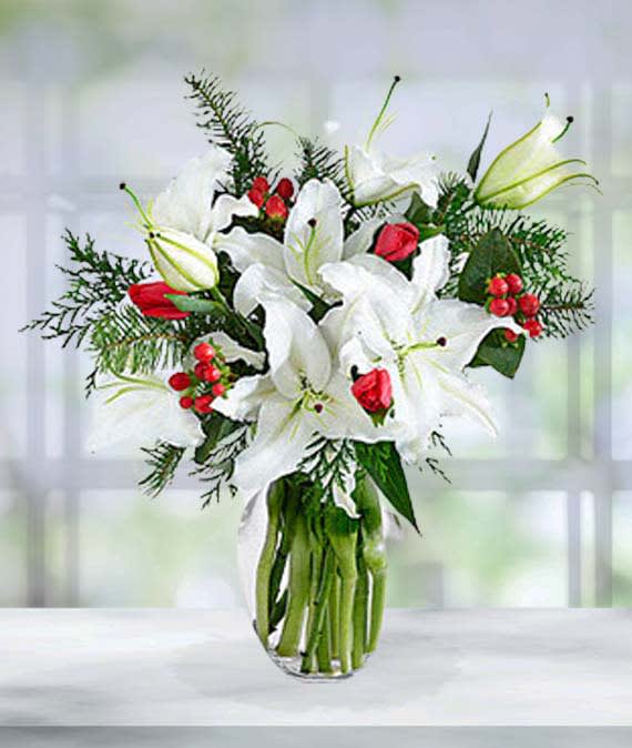 Stately lilies in a vase accented with reds. 