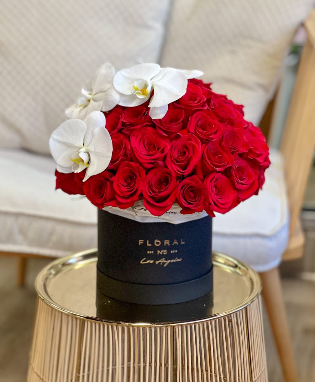 Luxury arrangement designed with Red Roses and Orchids in our signature black