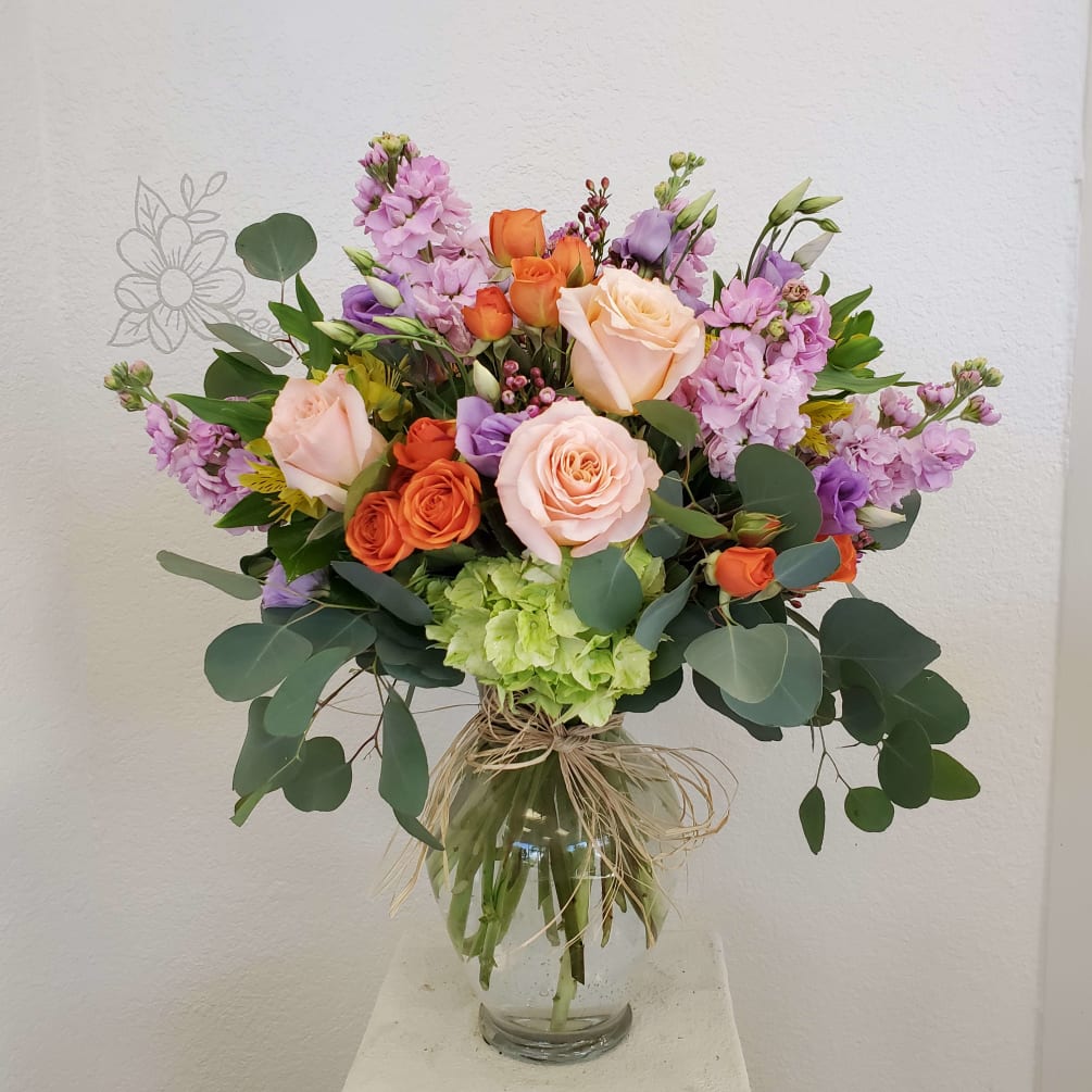 An Array of Lavender, Orange and Peach flowers in a ginger vase.
