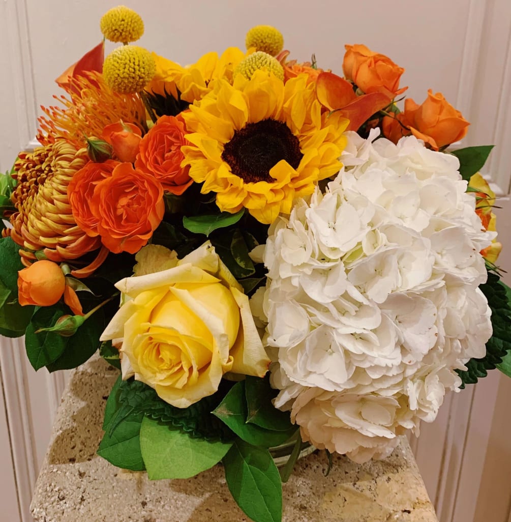Sunflowers, hydrangeas, roses, and more! This arrangement just looks like fall, you