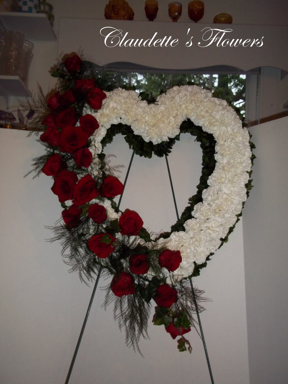 Red roses and white cushion mums make this a stunning tribute to