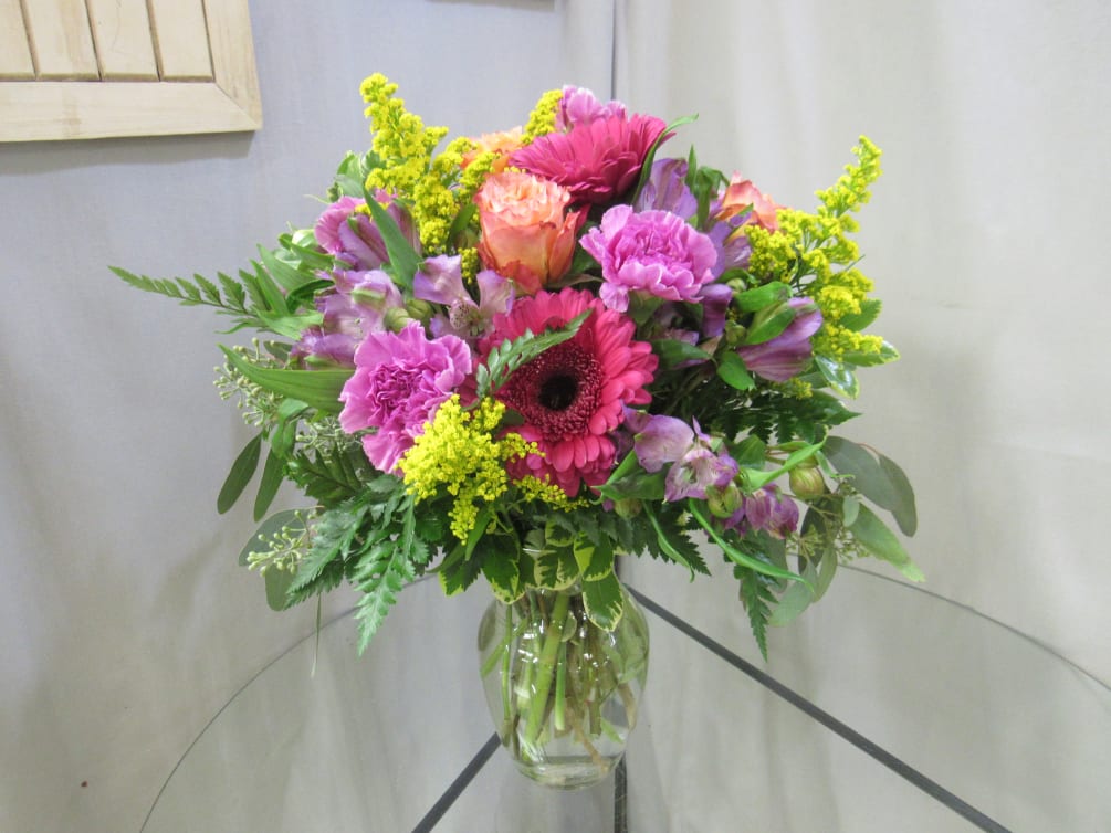 Vase arrangement of gerbera daisies, carnations and roses.