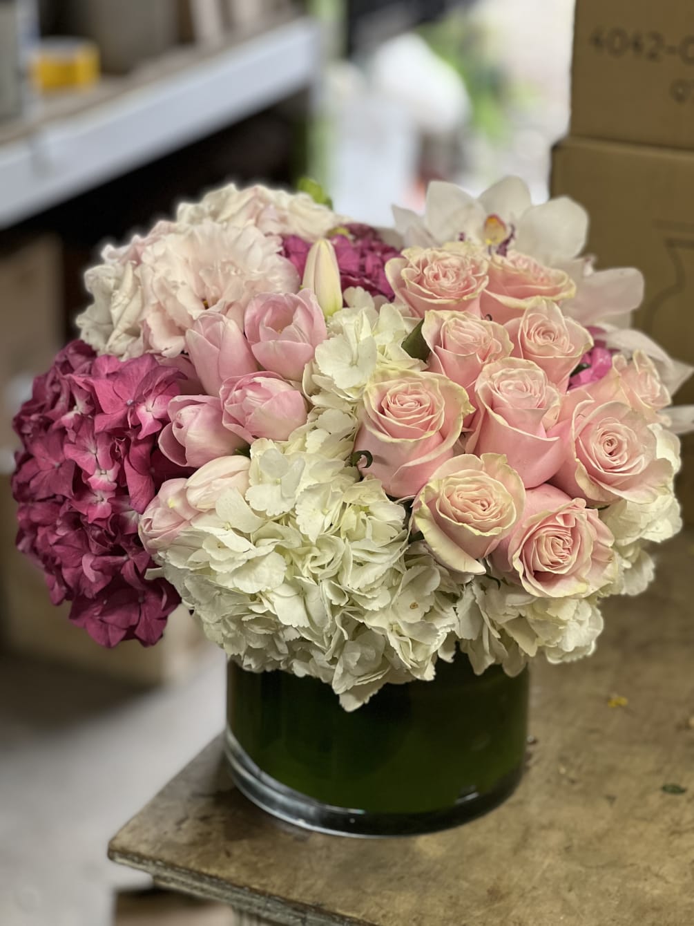 A luxurious, mix of roses, hydrangea, tulips and exotic Cymbidium Orchid blooms