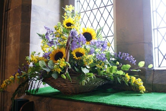 Basket-sunflowers, blue delphinium, yellow filler and mixed greens