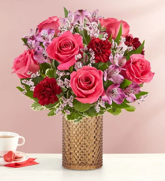 Hot pink roses, purple alstroemeria, burgundy carnations and pink limonium make up
