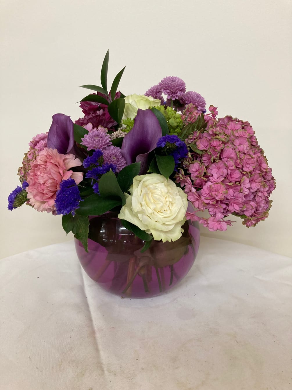 Purple calla lilies, pink hydrangea, white rose, pink carnation, lavender cushions, with