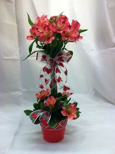 Pink peruvian lilies make this lovely topiary in a festive container an