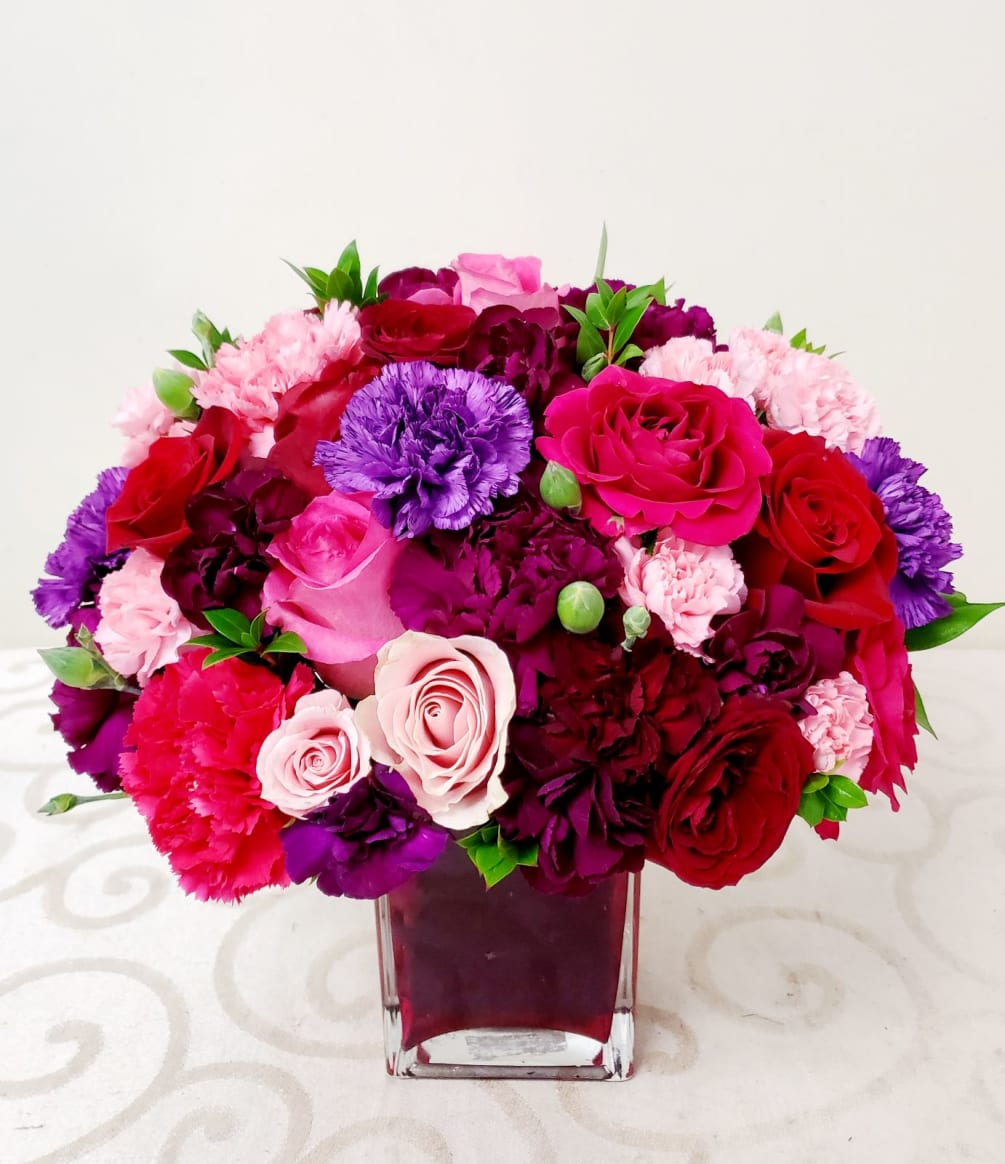 The combination of deep and dainty colors of roses and carnations creates