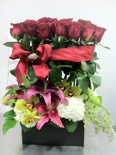 Stunning arrangement featuring red roses, lilies, and orchids