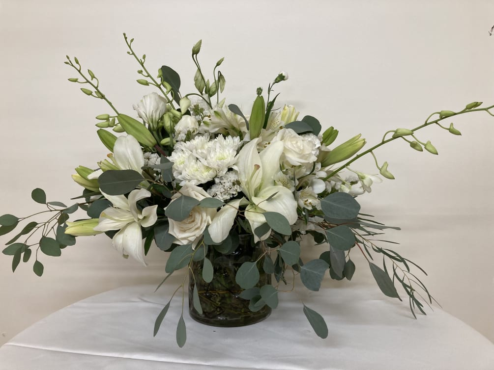 White lilies and roses set in the embrace of eucalyptus.