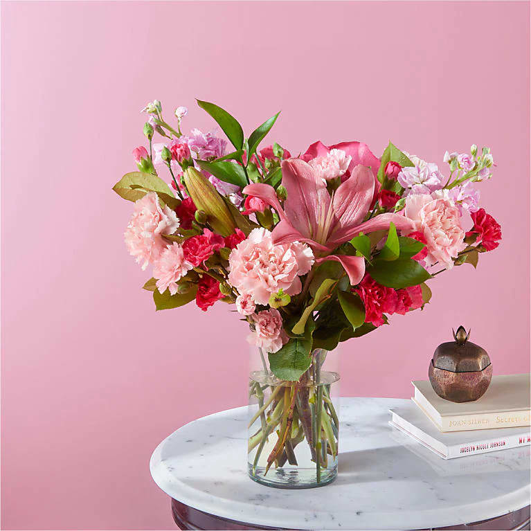 Carnations, roses, or lilies arrive fresh in the full spectrum of pink