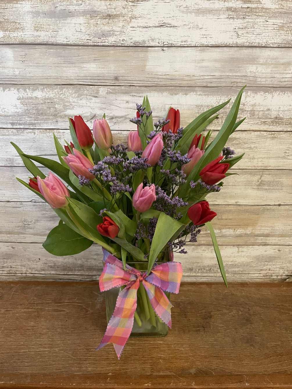 20 Lovely tulips arranged in a clear glass vase. Color will vary