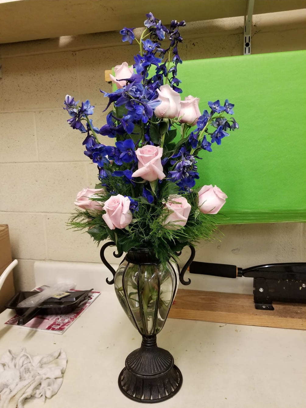 12 light pink roses and 9 blue delphinium. Vase will vary.
