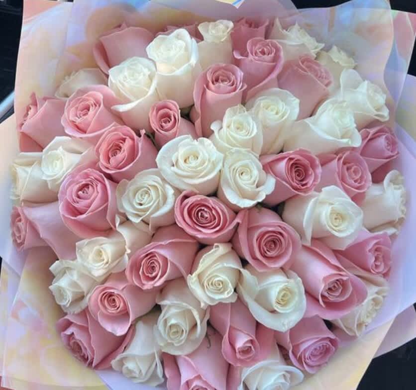Pink and white roses wrapped in specialty tissue 