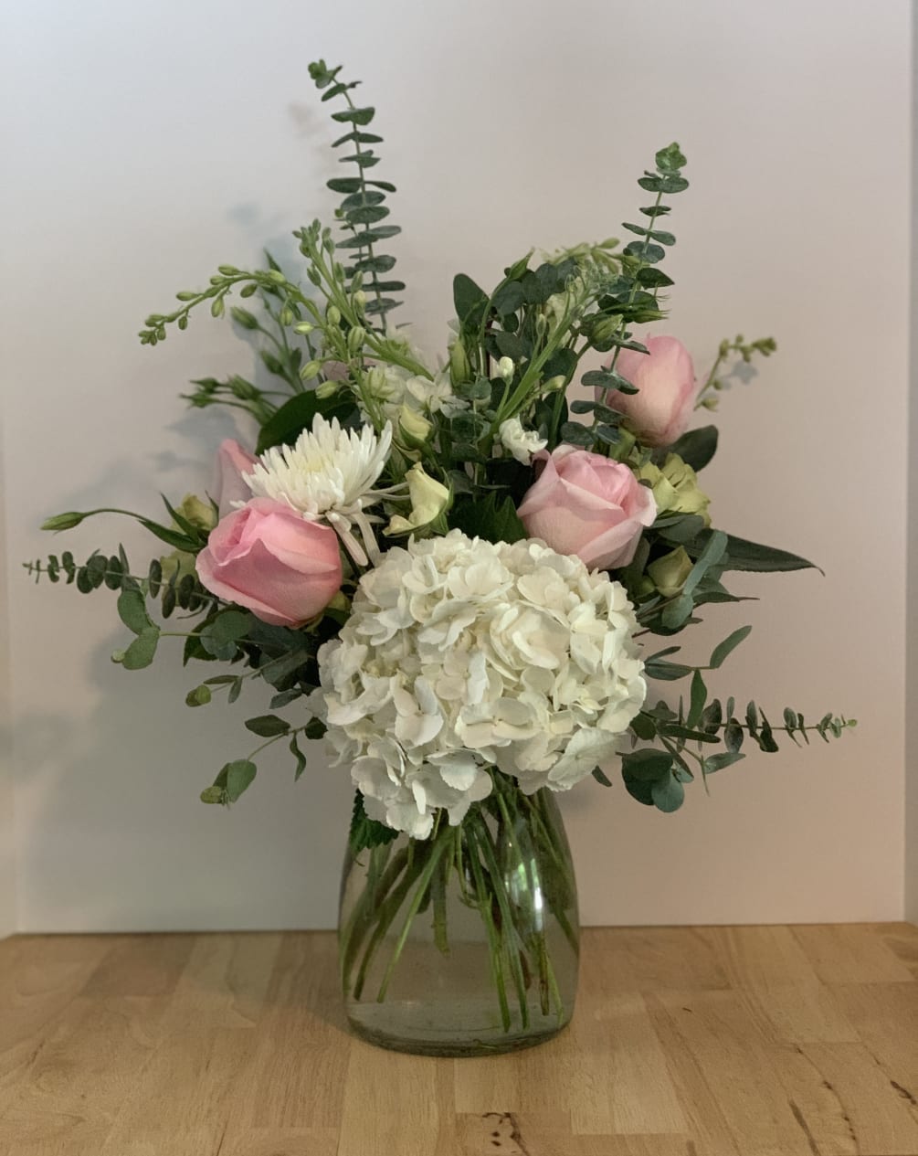 This fun bouquet contains white hydrangea, pink roses, larkspur and euchalyptus. Perfect