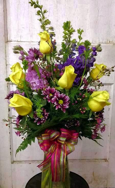 Six yellow roses mixed with an assortment of purple is a sure