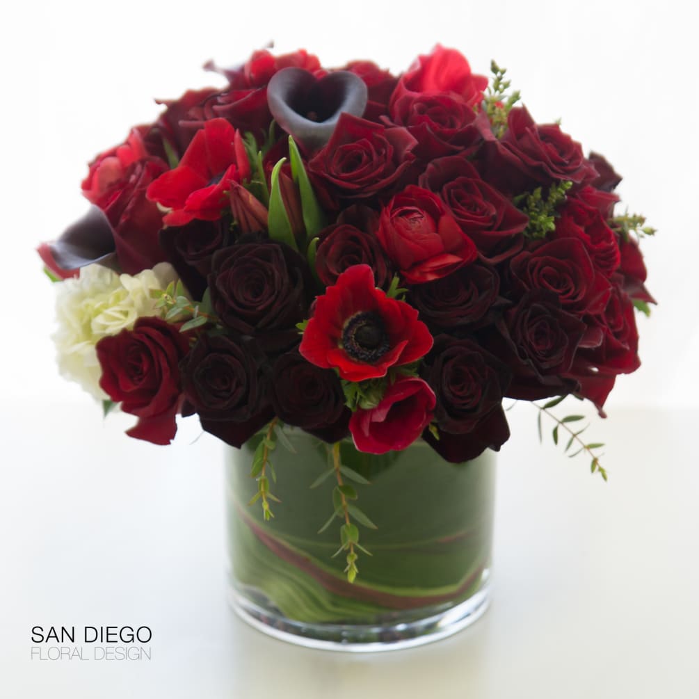 Lush arrangements of roses, tulips, mini callas in red and deep burgundy