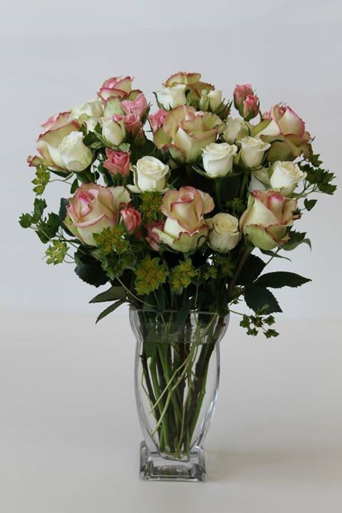 In this arrangement Roses and spray roses in different shades have been