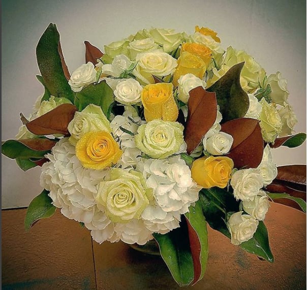 yellow white and cream roses  with a pillow of white 