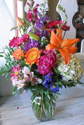 Beautiful orange lilies, pink dianthus, iris, and seasonal summer flowers to brighten