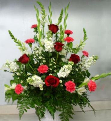     An A-line basket arrangement with gladiolus, carnations, roses