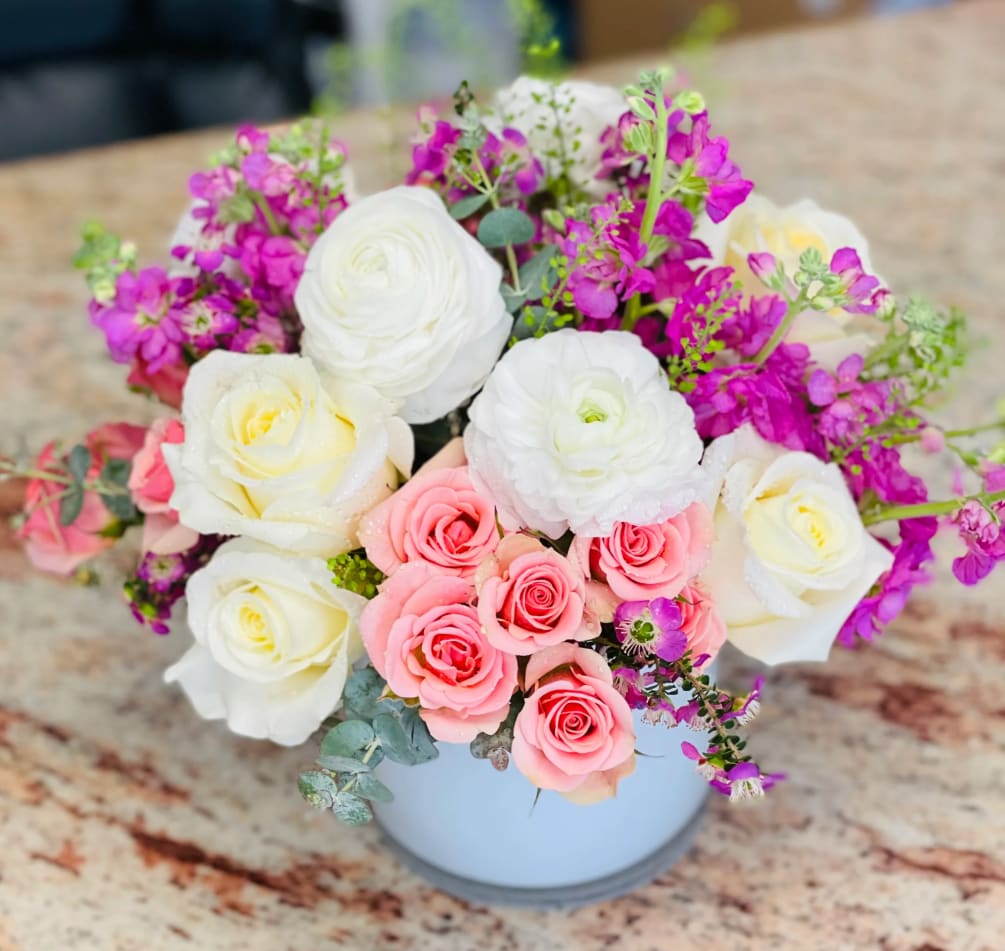 This collection of mixed pink, purple and whites blooms includes roses, spray