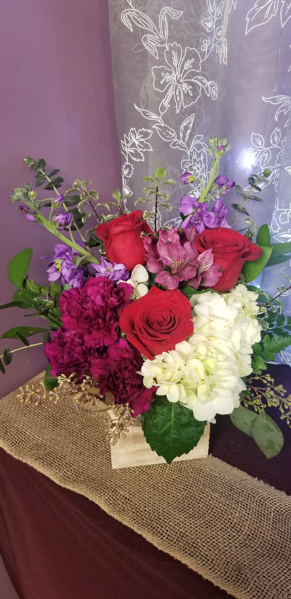 Designed in a wooden cube with a hydrangea roses, stock, alstroemeria, and
