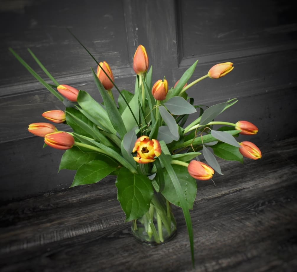 15 fresh cut tulips, simply designed in a clear glass vase. 
