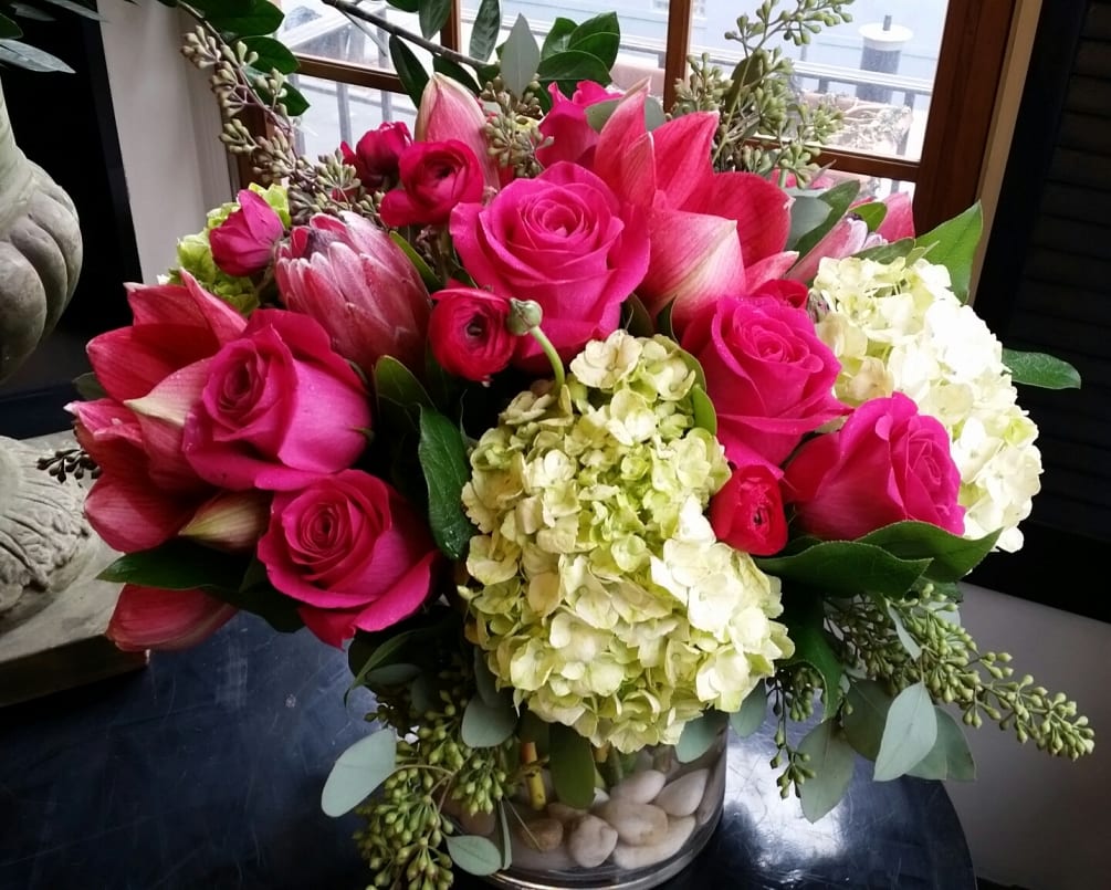 A show stopping pink and green arrangement using hot pink Roses, cloud