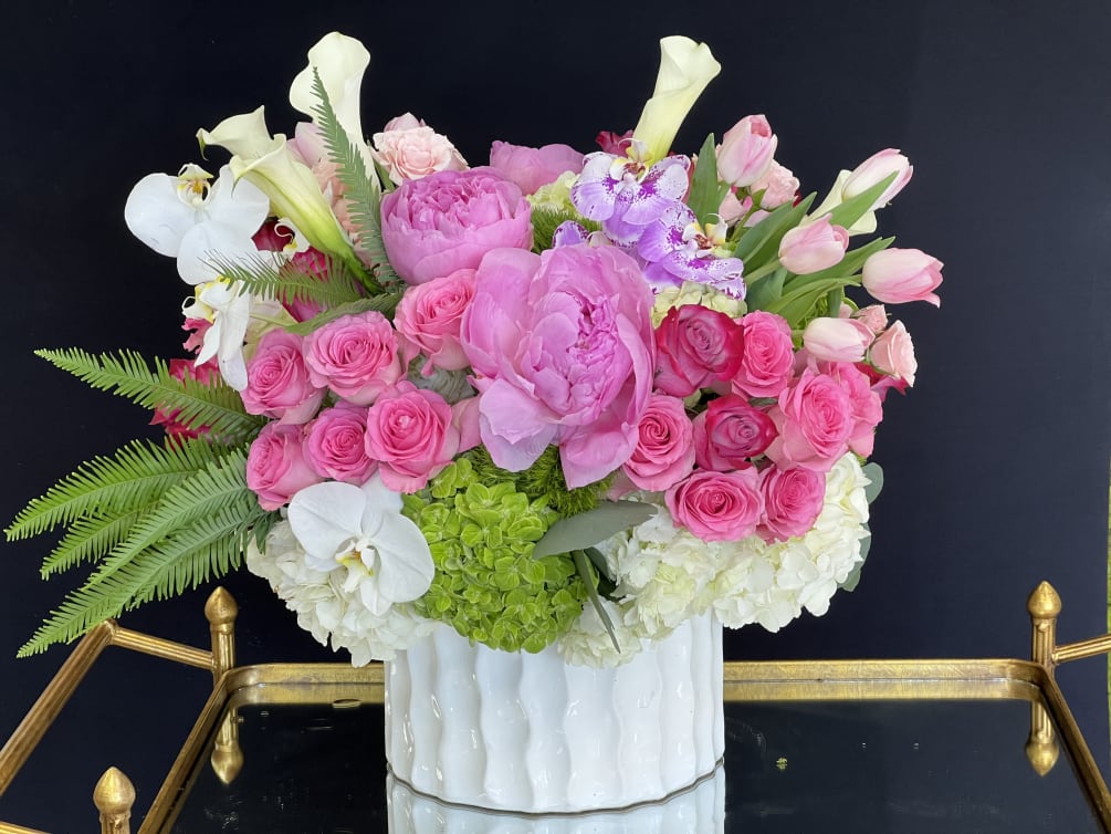 White hydrangeas, jeweled white cymbidium orchids, lavender and pink roses, and pale