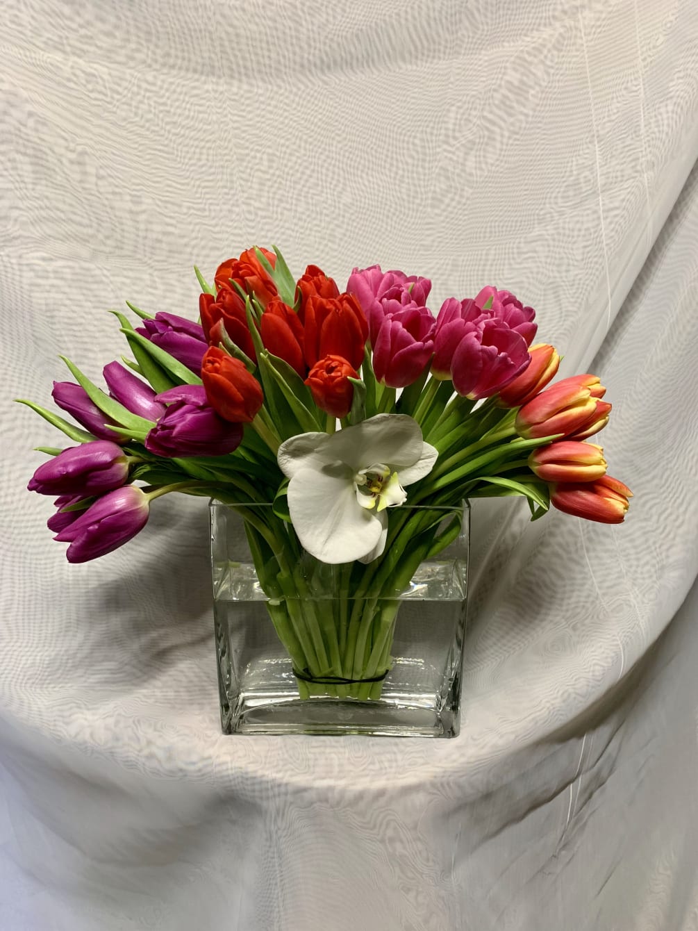 A beautiful modern arrangement with mix colors tulip&rsquo;s and orchid flower