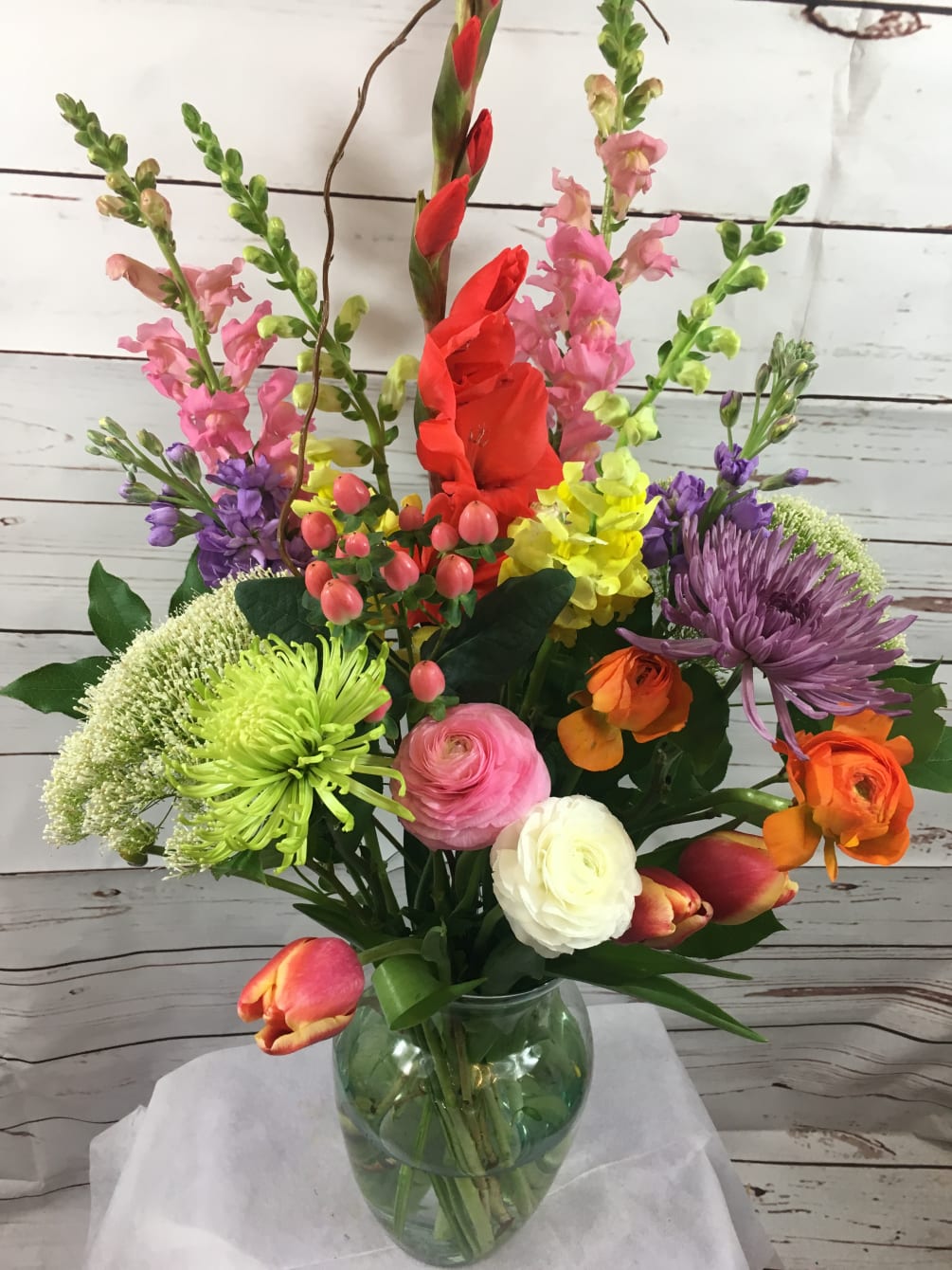 A colorful combination of spring flowers such as tulips,ranunculus,hypericum berries,gladiola,snap dragons,spider mums