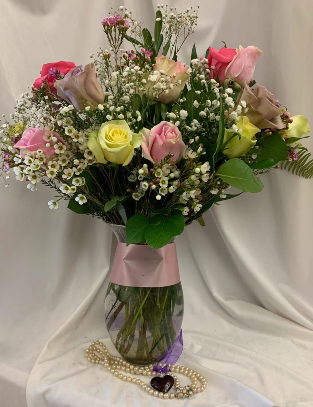 A dozen soft, pastel colored roses reminiscent of the gentle love of