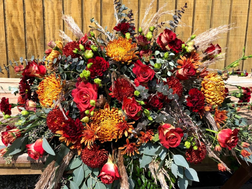 Sunflowers and roses, accented with lily pods and a tinge of wheat