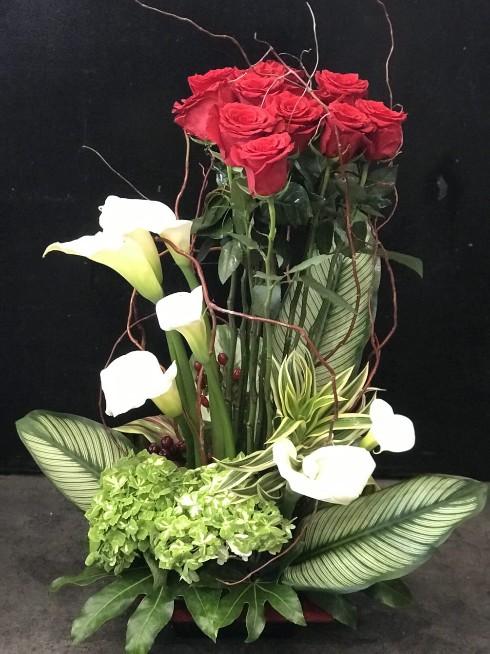 red roses, white cala lilies, curly willow, red hypericum