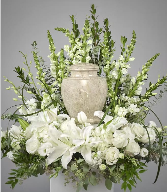 Elegant and soft, this all white urn tribute will include lilies, roses