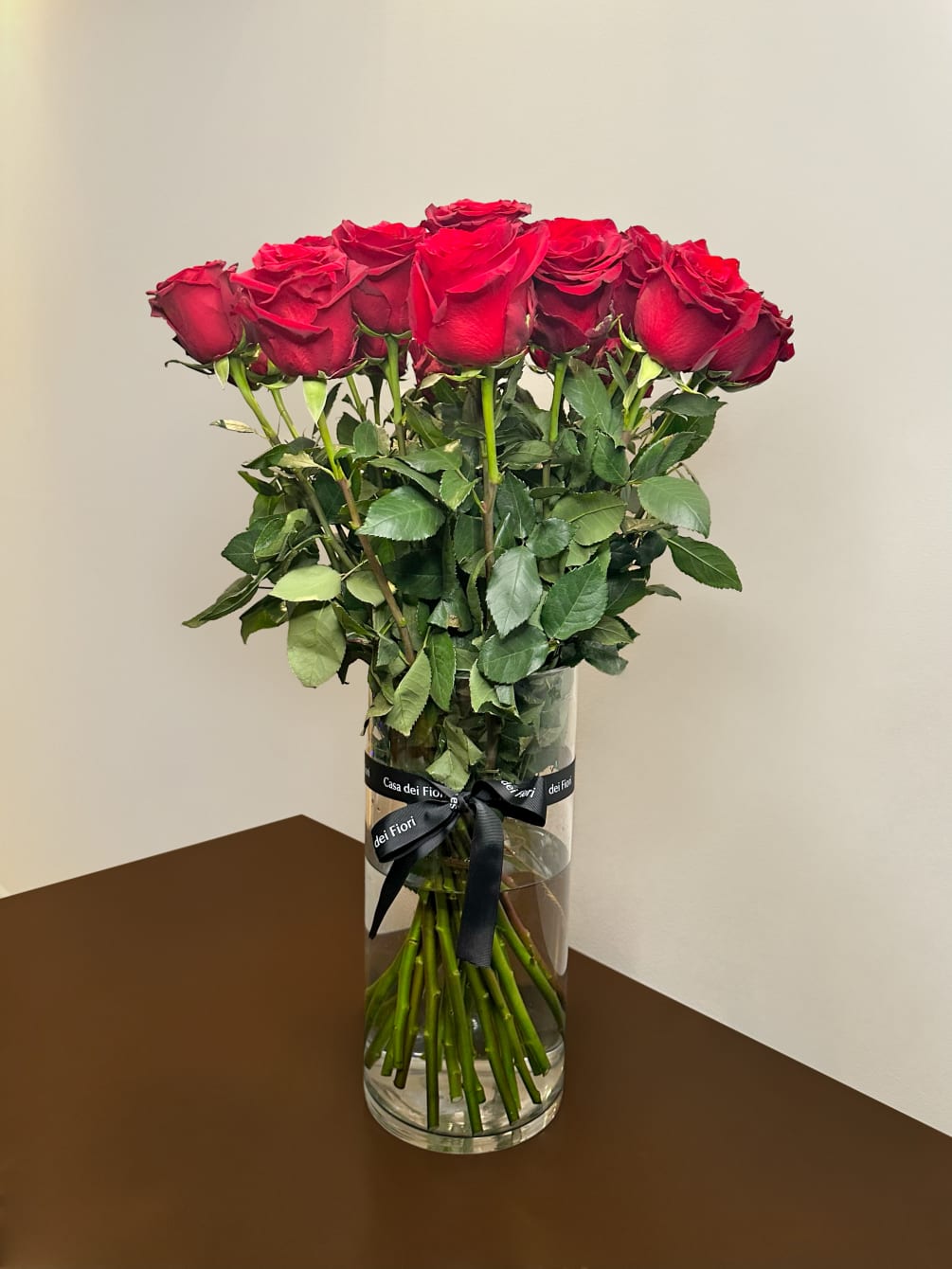 Gorgeous red long stem roses in a tall vase