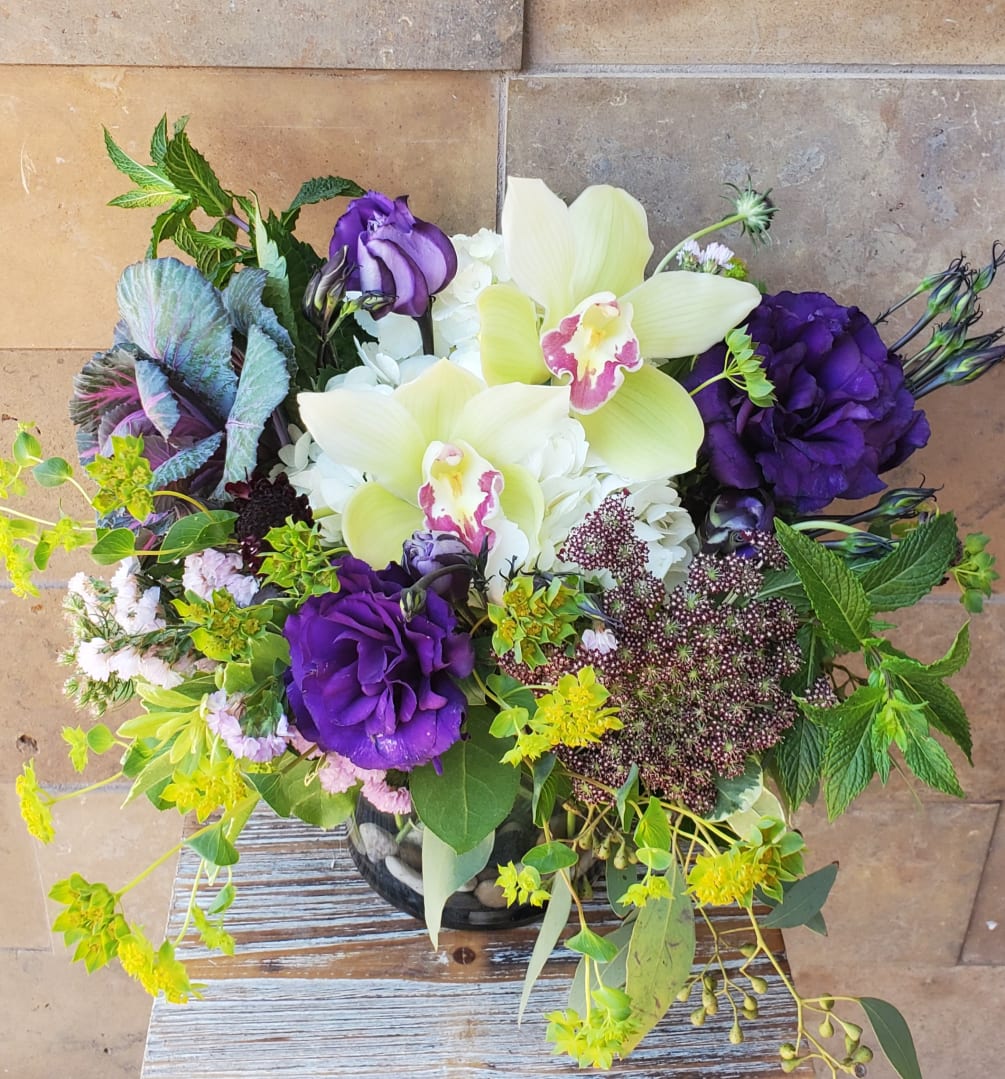 Green orchids and purple blossoms make an incredible combination. Cheerful design low