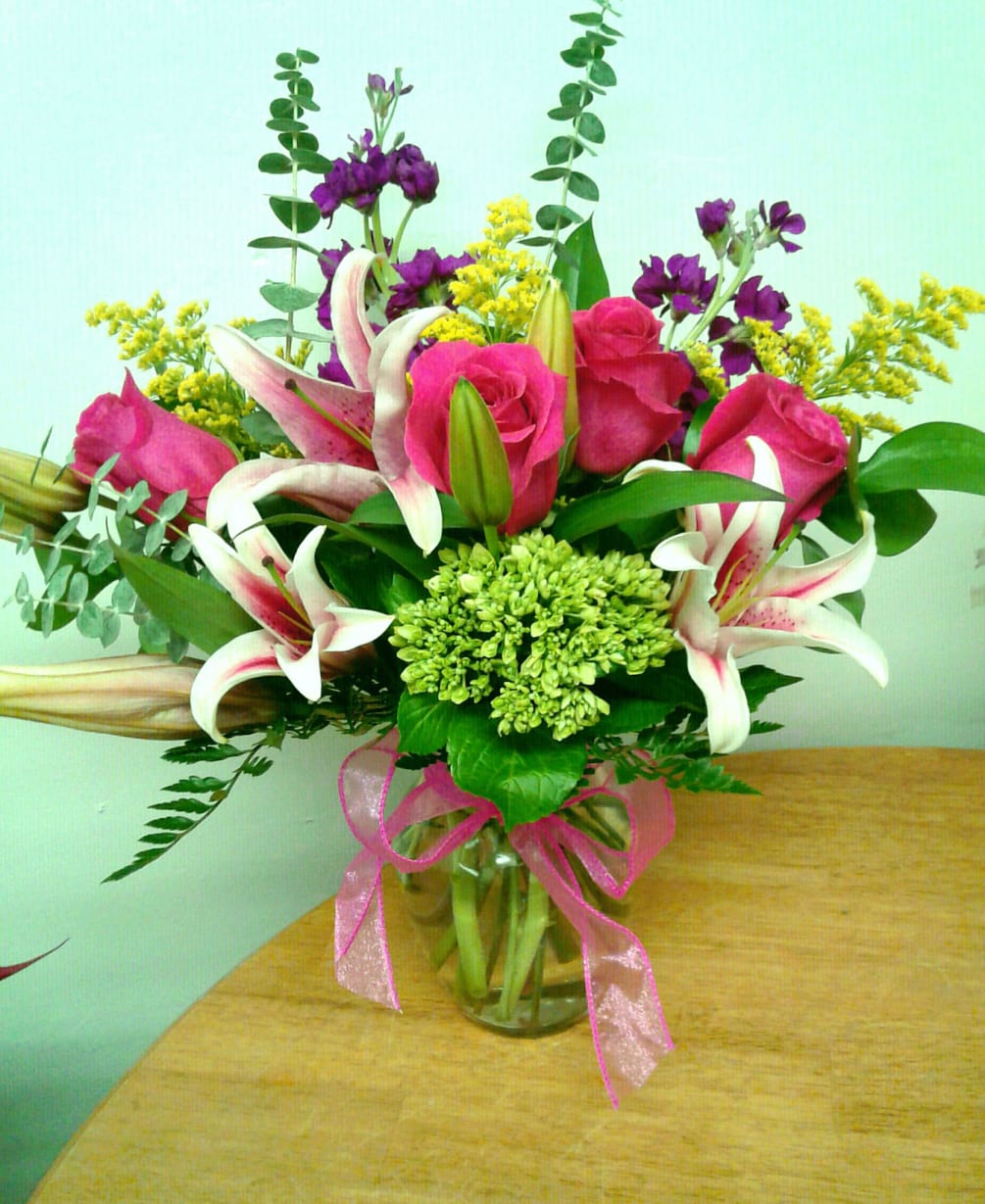 This bright colorful arrangement includes vibrant stargazer lilies, hot pink roses, fragrant