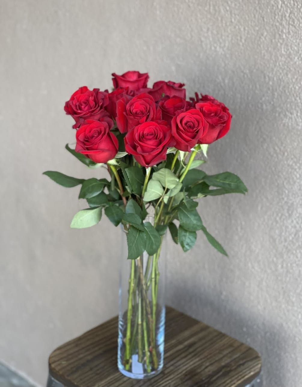 A dozen red roses in a vase make the perfect gift for