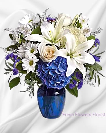Blooms such as blue hydrangea, cr&egrave;me roses, graceful white oriental lilies, white